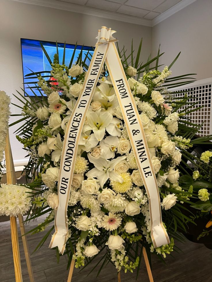 Florist arranging a tasteful white sympathy wreath
